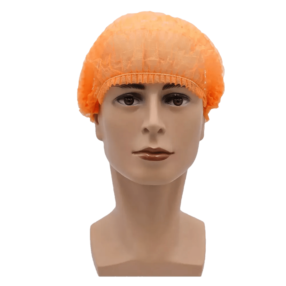 A imagem mostra uma cabeça de boneca com uma touca laranja AMPri MED-COMFORT Klipphaube 52 cm da AMPri Handelsgesellschaft mbH. O fundo é simples e branco. A touca de polipropileno cobre toda a cabeça e se ajusta firmemente à linha do cabelo, proporcionando assim proteção higiênica.