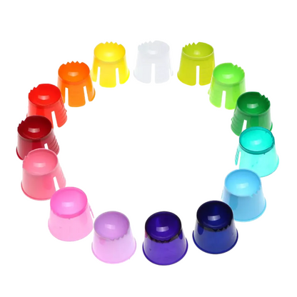 Mostra-se uma disposição circular de tampas coloridas de recipientes descartáveis AMPri PP Dappen nas cores vermelho, laranja, amarelo, branco, verde, azul, roxo e rosa em um padrão de gradiente harmonioso diante de um fundo branco brilhante.