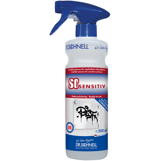 Um frasco pulverizador de 500 ml do removedor de graffiti DR.SCHNELL SC SENSITIV para superfícies sensíveis, com bico azul e um rótulo com informações sobre o produto e graffiti numa parede.