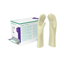 Karton mit sterilen, puderfreien Latexhandschuhen B. Braun Vasco® OP Grip mit violetter und grüner Beschriftung; zwei stehen aufrecht neben dem geöffneten Karton und geben den Blick frei auf einzeln verpackte Handschuhe aus hochwertigem Naturkautschuklatex für eine zuverlässige Passform. Marke: B. Braun Deutschland GmbH & Co. KG.