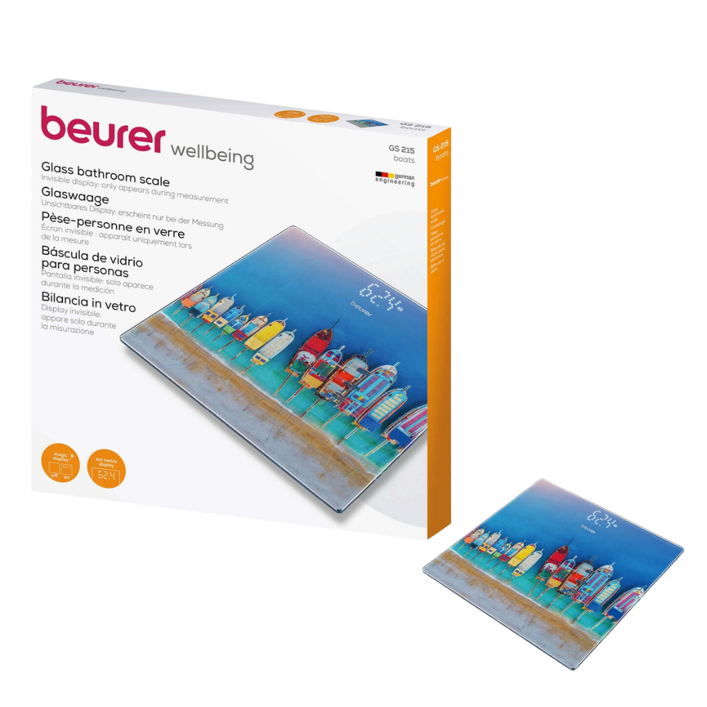 A imagem mostra a balança de vidro Beurer GS 215 da Beurer GmbH tanto na sua embalagem como como balança individual. A balança apresenta uma ilustração colorida de casas de praia e um farol, bem como um Magic-Display para melhor visibilidade. A embalagem com a inscrição "Beurer GS 215 Balança de Vidro | Embalagem (1 peça)" oferece informações sobre o produto em vários idiomas.