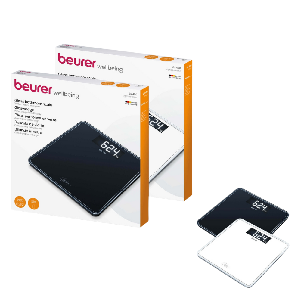 Duas balanças corporais Beurer GS 400 SignatureLine de vidro, uma preta e uma branca, são mostradas ao lado de suas respectivas caixas de embalagem. A embalagem contém a marca e as informações do produto da Beurer GmbH. A balança preta mostra "62,4" no seu visor digital.
