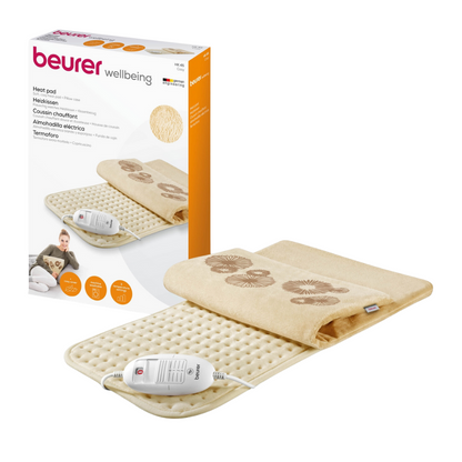 Imagem de um Beurer conjunto de almofadas térmicas HK 45 Cosy. O conjunto inclui uma almofada térmica elétrica de cor creme com superfície texturizada e unidade de controle conectada. Ao lado da almofada está a caixa de embalagem do produto com imagens e descrições em vários idiomas. A almofada da Beurer GmbH cumpre a certificação OEKO-TEX® Standard 100.