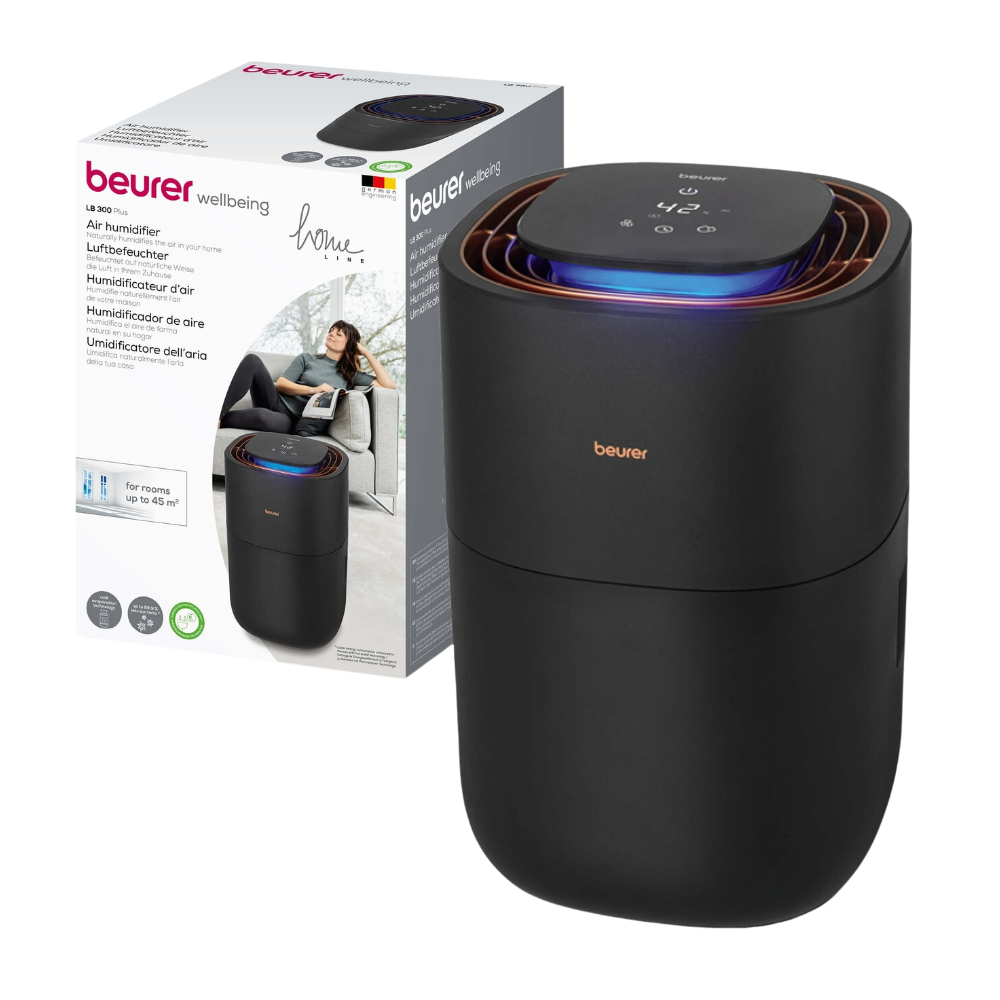 Na embalagem está ilustrado um humidificador de ar preto Beurer LB 300 da Beurer GmbH com um painel de controle digital na parte superior. A embalagem mostra uma marca e a imagem de uma mulher relaxando, indicando que o produto é destinado para uso doméstico. O texto multilíngue destaca os benefícios do produto para um ar ambiente higiénico.