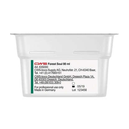 Um recipiente retangular branco com a inscrição "CWS ParadiseLine Fragrância para Casa de Banho para Dispensador de Fragrâncias Paradise Air Bar" da CWS mostra em uma etiqueta branca informações de produto e empresa, dados de contato, a data de fabricação (05/19) e o número do lote (123456).