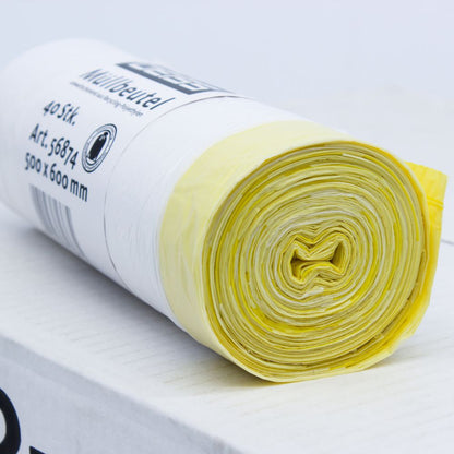 Um pacote enrolado de sacos de lixo DEISS 56874 de 30 litros com cordão da EMIL DEISS KG (GmbH + Co.), com sacos de plástico amarelos e brancos sobre um fundo branco. A etiqueta no rolo indica as dimensões de 500 x 600 mm e informa que contém 40 unidades com uma capacidade de 30 litros cada.