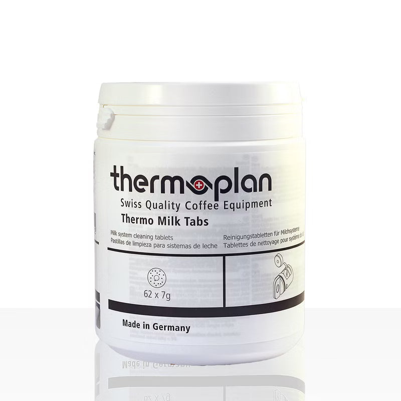 Um recipiente de plástico branco com a inscrição "Thermoplan Thermo Milk Tabs, pastilha de limpeza para máquinas de espresso | Embalagem (62 unidades)" da Diversey Deutschland GmbH & Co. OHG, para a limpeza higiénica, mostra "62 x 7g", "Made in Germany" e informações multilíngues.