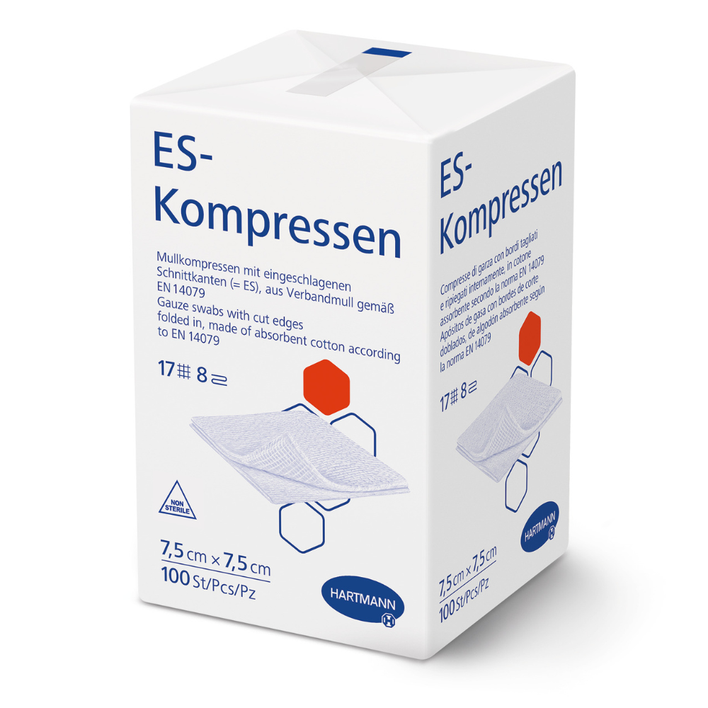 Uma caixa branca com a inscrição "Compressas ES da Hartmann de vários tamanhos, não estéreis" da Paul Hartmann AG exibe uma informação do produto em língua alemã, as medidas 7,5 x 7,5 cm, 100 unidades, uma imagem de compressas de gaze para o tratamento de feridas e o logotipo da Hartmann na parte inferior.