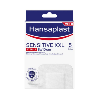 Uma caixa com Hansaplast Sensitive XL, estéril, especialmente amigável à pele, tiras estéreis nas dimensões de 8x10 cm. A caixa contém 5 tiras e destaca-se por propriedades especiais como alta compatibilidade com a pele e alta capacidade de absorção. A embalagem também leva o rótulo "Bacterial Shield", garantindo assim um cuidado de feridas de primeira classe da Beiersdorf AG.