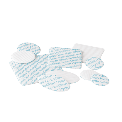 Uma coleção de quatro coberturas de feridas Hartmann HydroClean® brancas e azuis da Paul Hartmann AG, dispostas sobre um fundo branco.