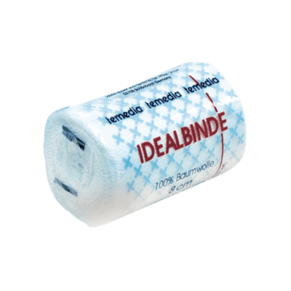 Uma ligadura de gaze branca enrolada com a inscrição "Holthaus Temedia® Idealbinde, com clipe de bandagem - 1 ligadura" e texto vermelho. A embalagem apresenta um padrão de cruz azul e mostra "100 % algodão" e "8 cm". O nome da marca "Holthaus Medical GmbH & Co. KG" é repetido em azul na parte superior.