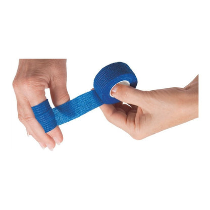 Duas mãos enrolam um curativo de dedo azul BeeSana© SafeCut da Meditrade GmbH em um dedo. Uma mão segura o rolo enquanto a outra fixa o curativo elástico e sem látex no dedo.