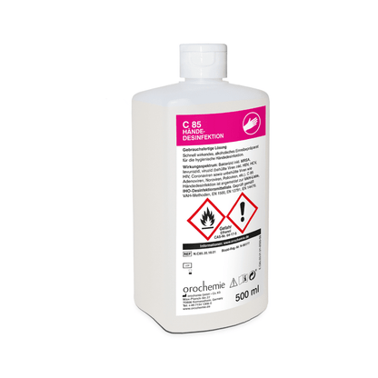 Uma garrafa de plástico branca de 500 ml com a inscrição "Orochemie C 85 Desinfetante para as mãos" da empresa orochemie GmbH + Co KG possui no rótulo frontal e na tampa fechada instruções de uso em alemão, símbolos de perigo e avisos de segurança, indicando que se trata de um produto para desinfecção higiênica das mãos.