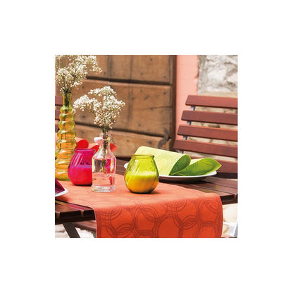 Uma mesa de madeira está decorada com um corredor de mesa PAPSTAR semelhante a tecido PV-Tissue Mix laranja-vermelho brilhante da Coleção ROYAL da PAPSTAR GmbH. Está decorado com vasos coloridos – vermelho, rosa, amarelo e laranja – alguns dos quais contêm flores brancas. Folhas verdes estão artisticamente colocadas ao lado dos vasos. Cadeiras de madeira cercam o arranjo elegante.