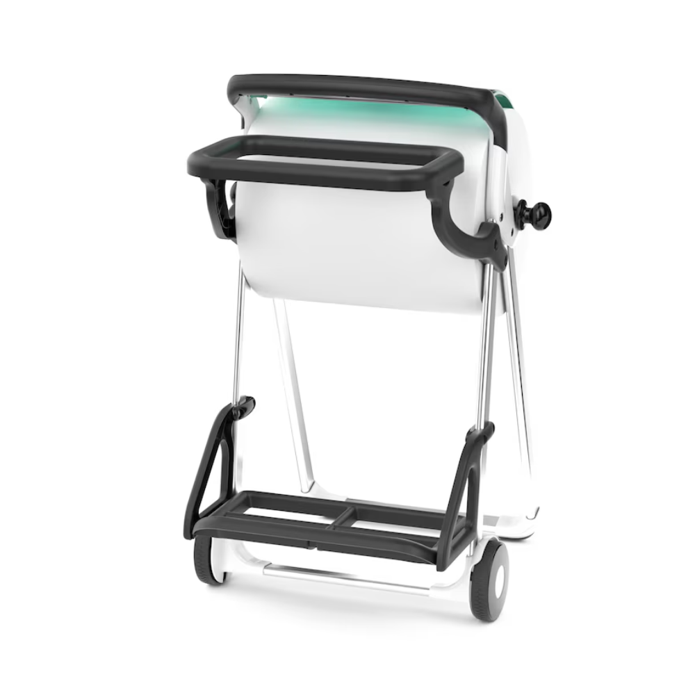 Um suporte para sacos de lixo Tork 206550 para suporte de chão em branco e preto, com rodas, uma alça e um rolo de papel ou tecido posicionado centralmente. A estrutura metálica assemelha-se a um suporte de chão e mostra o suporte para sacos de lixo Tork de uma perspectiva ligeiramente inclinada.