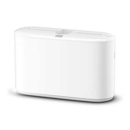 Um dispositivo eletrônico branco e retangular com bordas suaves e uma parte superior plana com uma ranhura central, que reflete o estilo elegante do dispensador de mesa Tork Xpress® 552200 para toalhas de mão multifolhas Elevation H2 da TORK – Essity Professional Hygiene Germany GmbH.