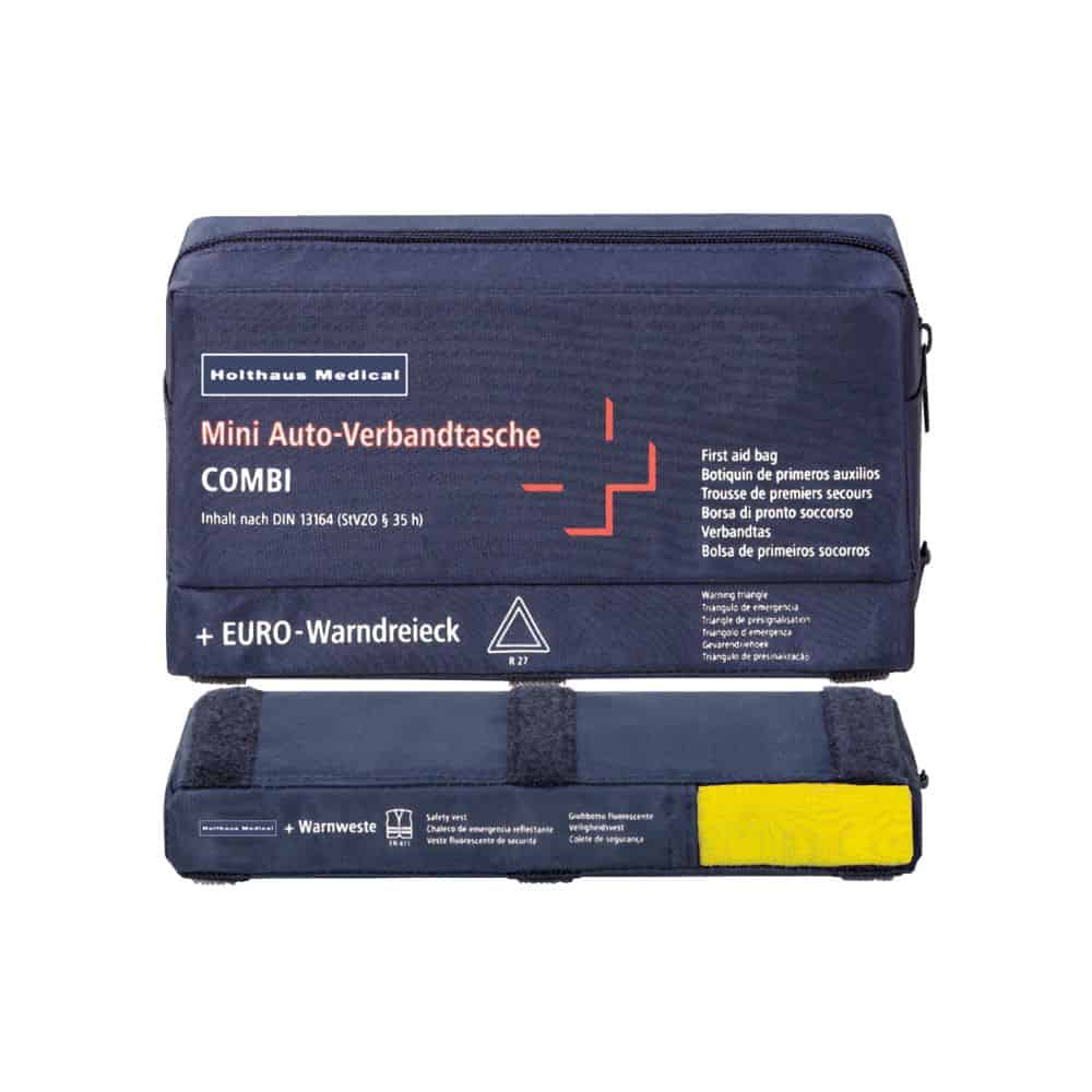 Uma mini-bolsa de primeiros socorros COMBI Auto da Holthaus Medical GmbH & Co. KG é azul e apresenta conteúdos rotulados em vários idiomas. Este kit de primeiros socorros contém um colete de aviso e um triângulo de aviso, com o colete amarelo claramente visível na parte inferior.