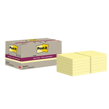 Uma caixa com a inscrição "Post-it® Super Sticky 100% Notas de Reciclagem, 47,6 mm x 47,6 mm, 70 folhas/bloco, 100% PEFC" da 3M Deutschland GmbH está ao lado de várias pilhas de notas quadradas amarelas.