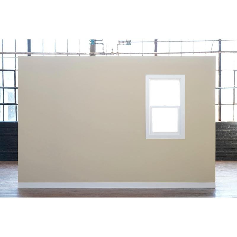 Uma parede bege com uma janela emoldurada de branco está em frente a grandes janelas industriais - ideal para pintar com fita adesiva Scotch® Classic, 24 mm x 50 m, da 3M Deutschland GmbH (70% PEFC, SGSCH-COC-110078) - em uma grande sala com piso de madeira.