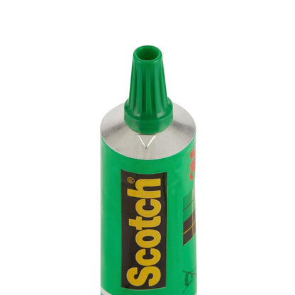 A close-up de um tubo aberto de cola líquida Scotch® (30 ml, 3M Deutschland GmbH) mostra o bico verde e a etiqueta preto-verde. A cola forte garante uma colagem confiável; disponível como 24 tubos por expositor ou como peças únicas.