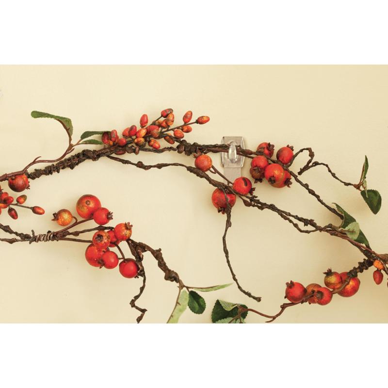 Um ramo decorativo com bagas vermelhas e folhas verdes está pendurado numa parede clara, fixado sem deixar marcas com o Mini-Gancho Command™ transparente, com tiras transparentes (17006CLR) da 3M Deutschland GmbH.