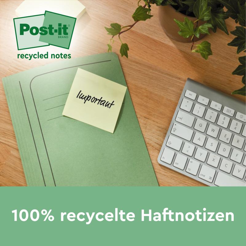 Uma pasta verde com um Post-it® Super Sticky 100% Nota de Reciclagem amarela (47,6 x 47,6 mm, 70 folhas/bloco, PEFC) da 3M Deutschland GmbH com a inscrição "importante" está sobre uma mesa de madeira ao lado de um teclado e uma planta. O texto está em alemão.