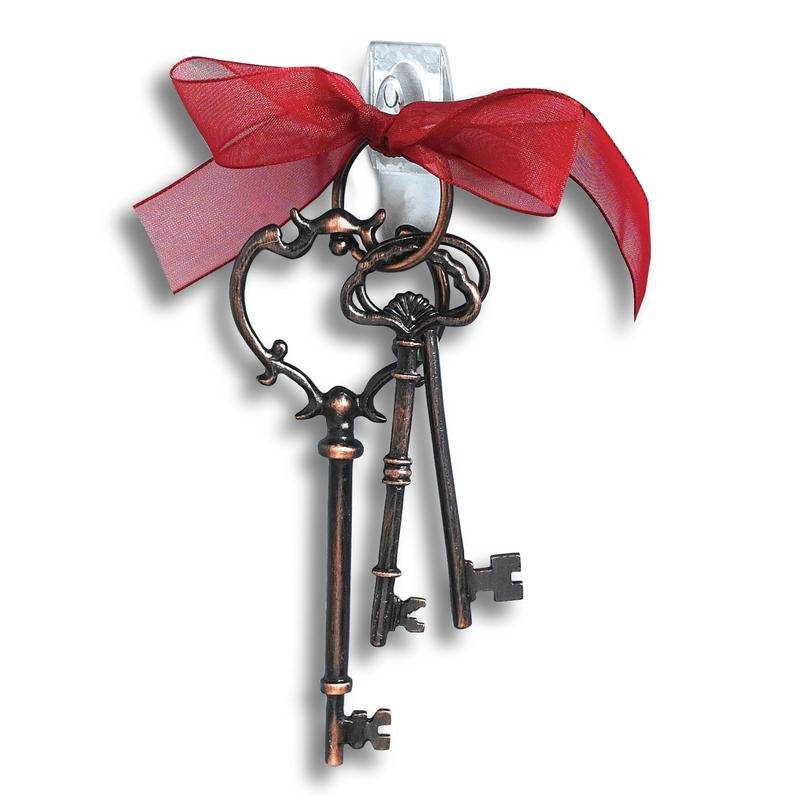 Três chaves de estilo vintage amarradas com uma fita vermelha são penduradas num fundo branco num Mini-Gancho Command™ transparente (17006CLR) da 3M. As tiras fornecidas permitem uma fixação fácil e sem marcas pela 3M Deutschland GmbH.