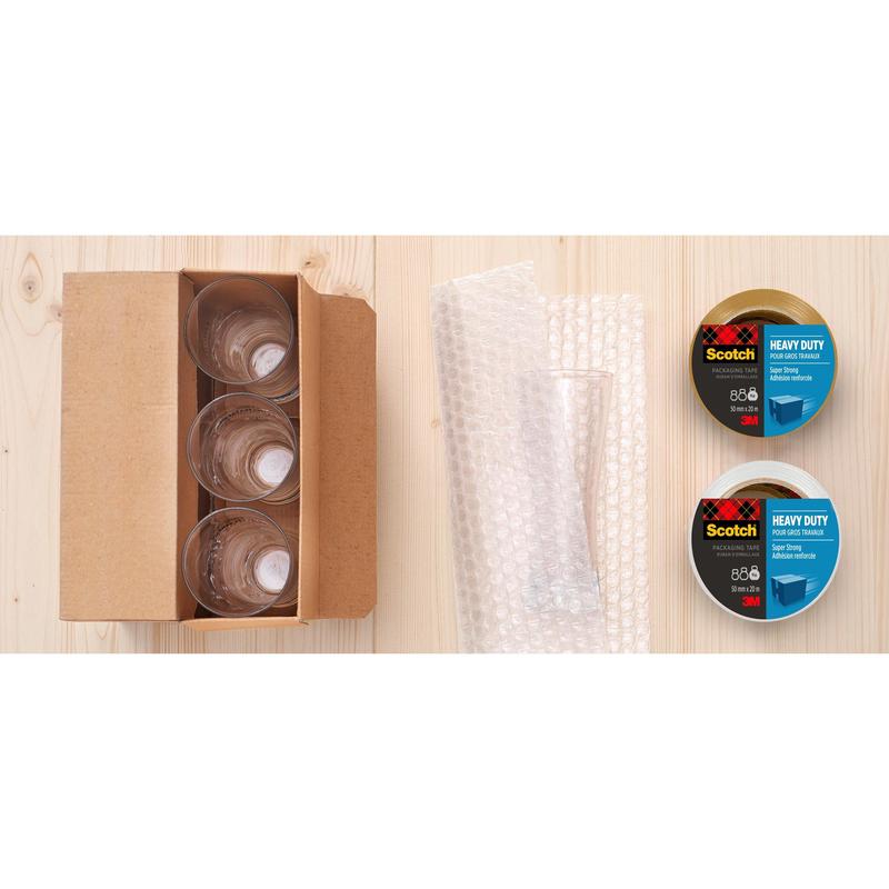 Uma caixa aberta com quatro copos de vidro, plástico bolha e uma fita adesiva de embalagem extra forte Scotch® (48 mm x 20,3 m) da 3M Deutschland GmbH está sobre uma superfície de madeira clara.