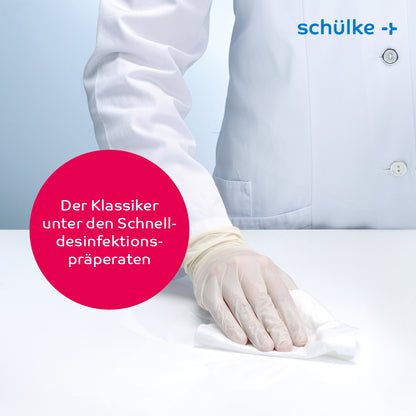 Uma pessoa de bata de laboratório branca e luvas limpa uma superfície com toalhetes desinfetantes Schülke mikrozid® AF wipes. Numa bolha de texto está escrito em alemão: "O clássico entre os preparativos de desinfeção rápida." No canto superior direito está o logotipo da empresa Schülke & Mayr GmbH, sublinhando o compromisso com a desinfeção rápida alcoólica.