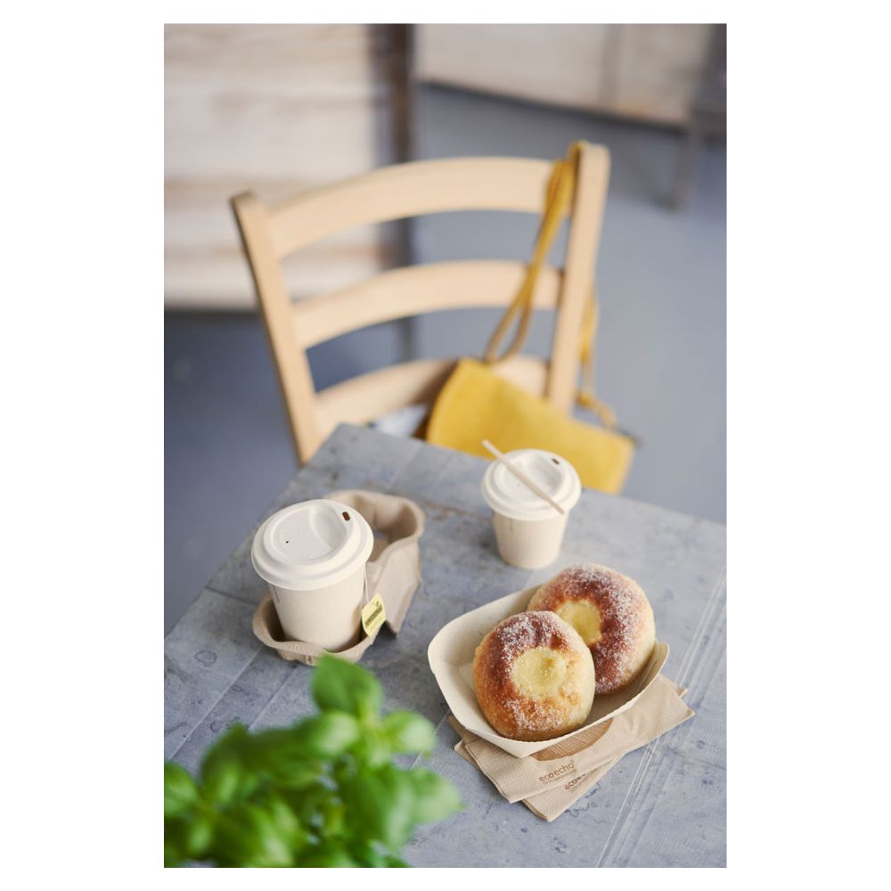 Auf einem Tisch liegen zwei mit Zucker bestäubte Gebäckstücke auf einem Tablett und zwei mit Deckel versehene Duni-Kaffeebecher „Sweet Bedruckte Bagasse“ von Duni GmbH. Eine gelbe Handtasche hängt an einem Holzstuhl, während eine teilweise sichtbare grüne Pflanze im Vordergrund das subtile Thema Nachhaltigkeit hervorhebt.